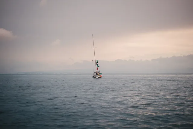 Un voilier seul sur une mer brumeuse