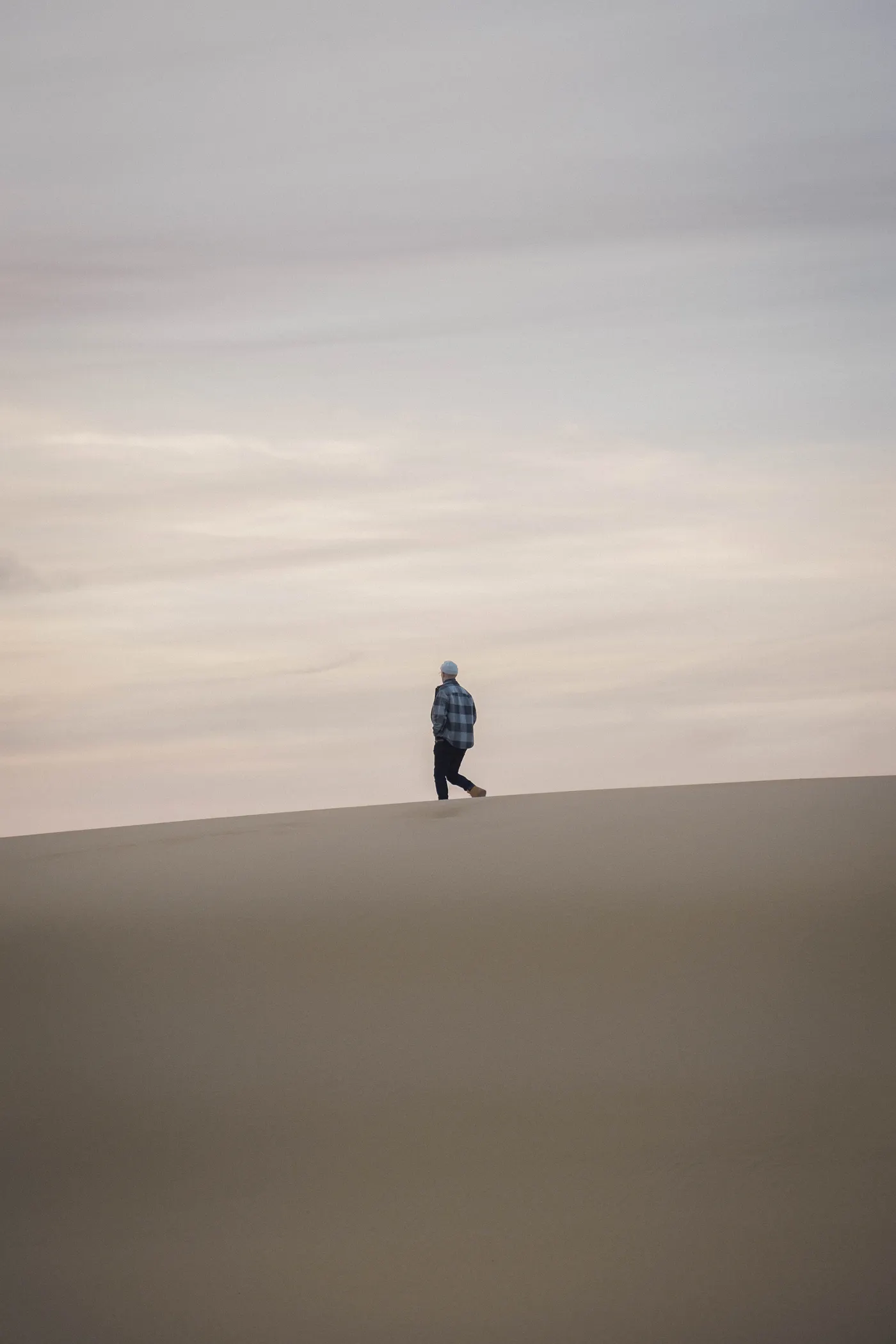 Une silhouette seule marche sur la crête de la Dune du Pilat