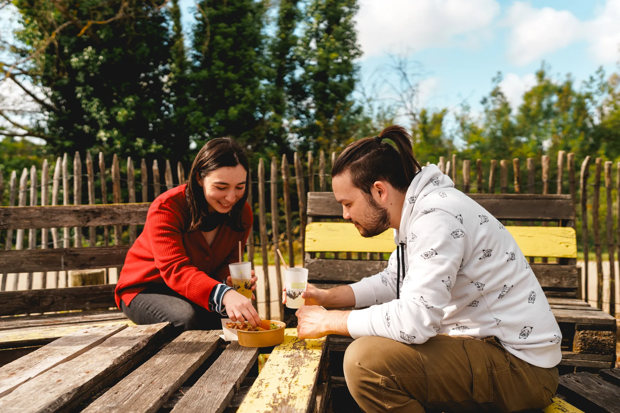 Un couple partage une assiette à une table de pique-nique