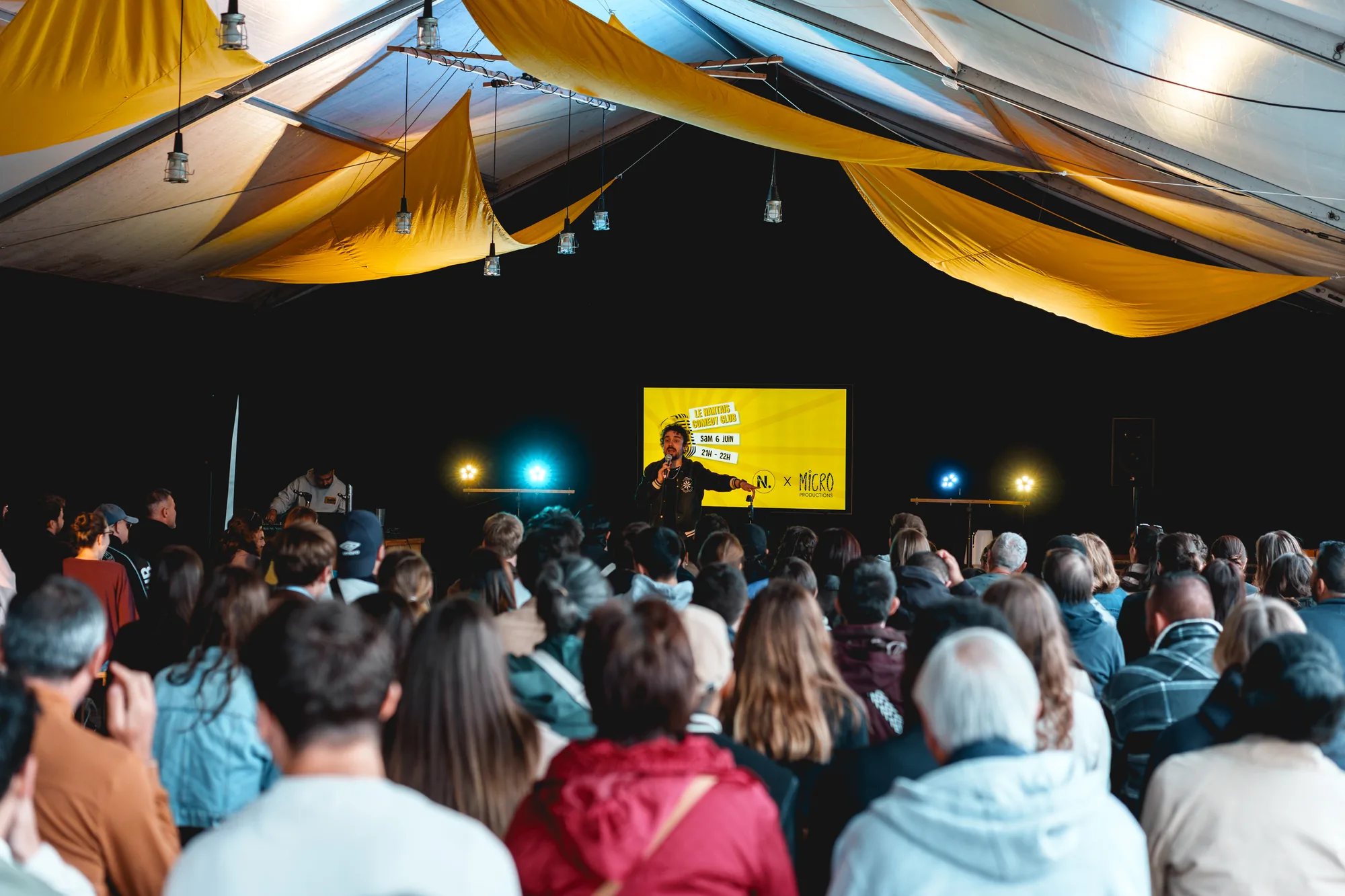 Public assis devant une projection sous la halle