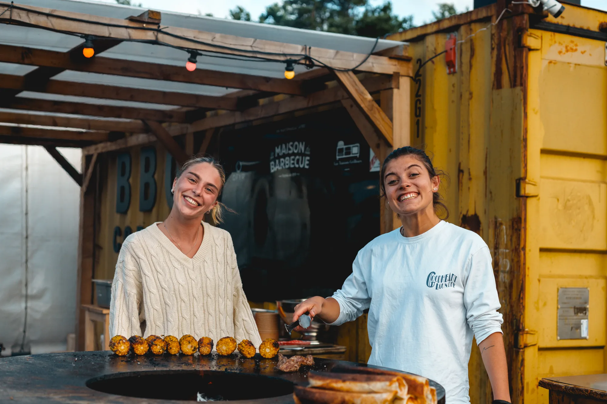 Deux membres de l'équipe présentent des brochettes devant le container