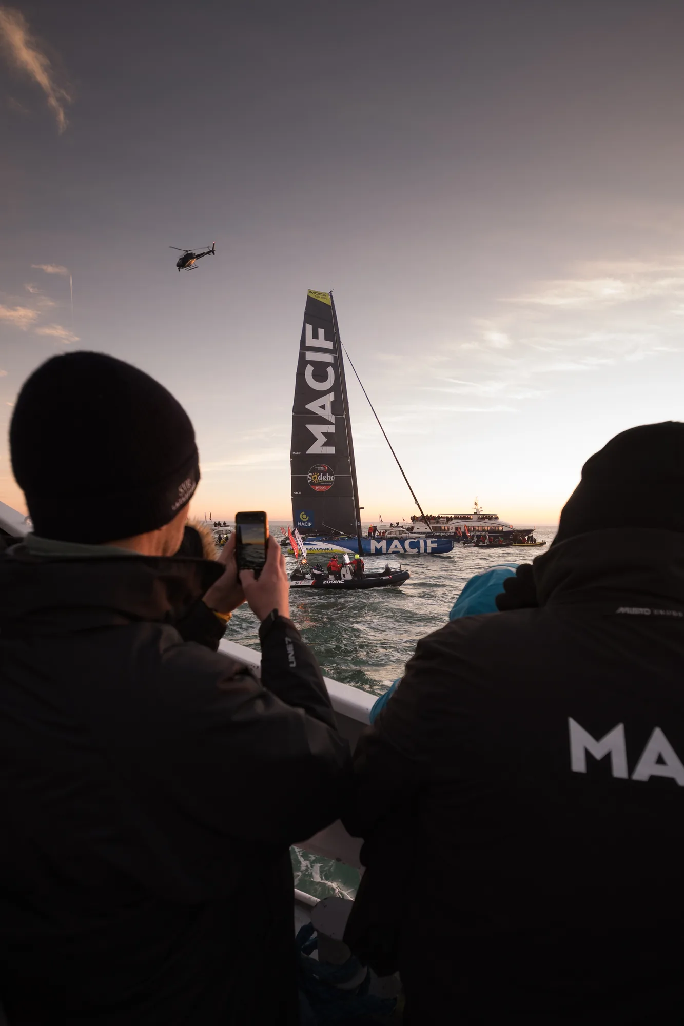 Deux membres du team Macif filment l'arrivée de l'IMOCA à l'aube