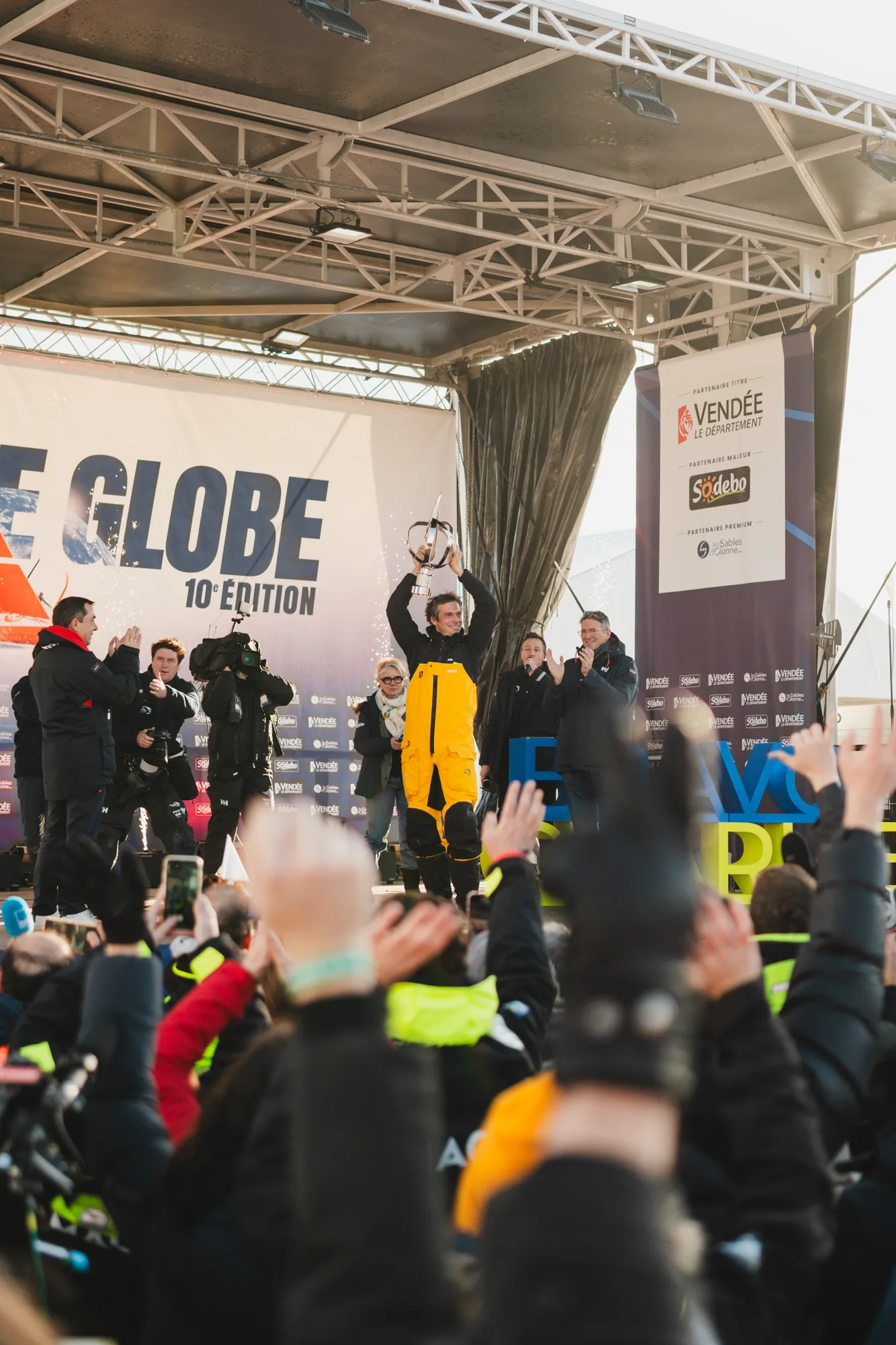 Mains levées dans la foule devant la scène du Vendée Globe